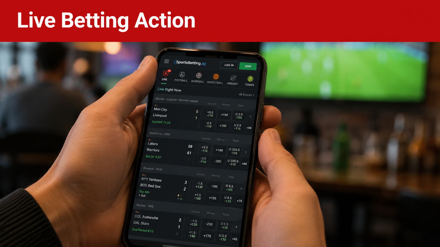 A person holding a smartphone showing the SportsBetting.ag mobile app interface with various live betting sports events.