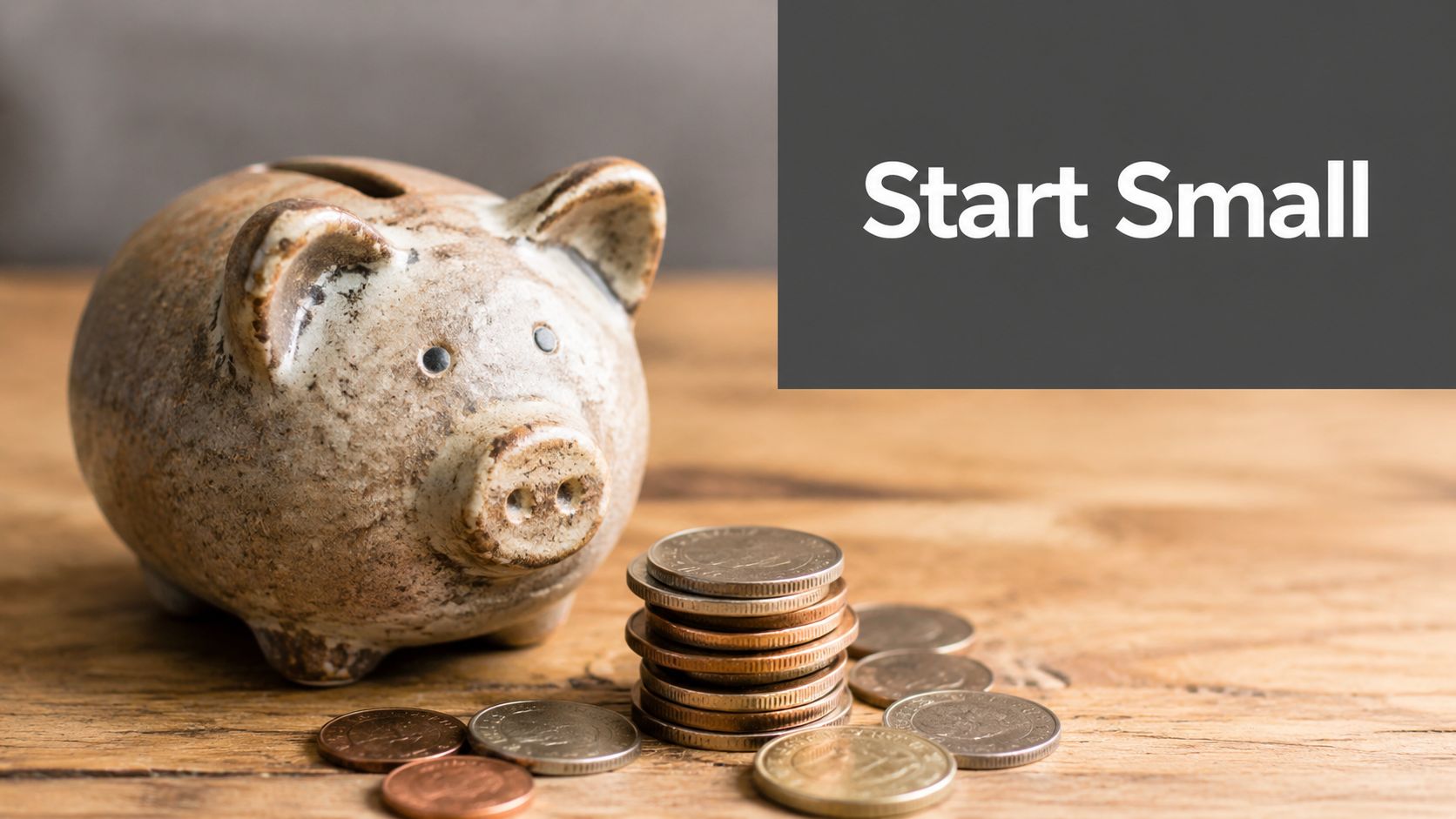 A ceramic piggy bank sitting next to a small stack of coins on a wooden table.