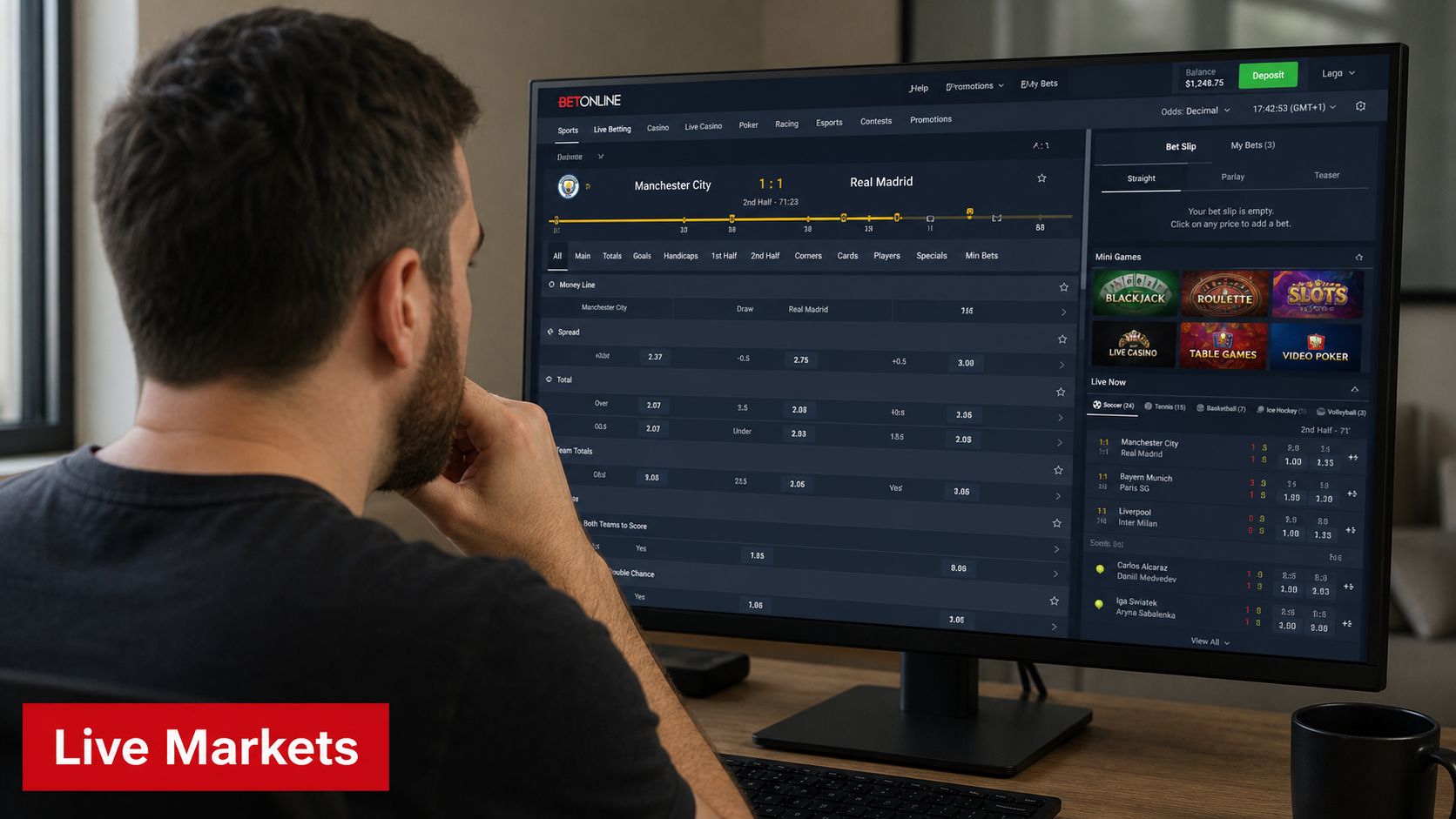 A person looking at a desktop monitor displaying a BetOnline sports betting website with live game odds.